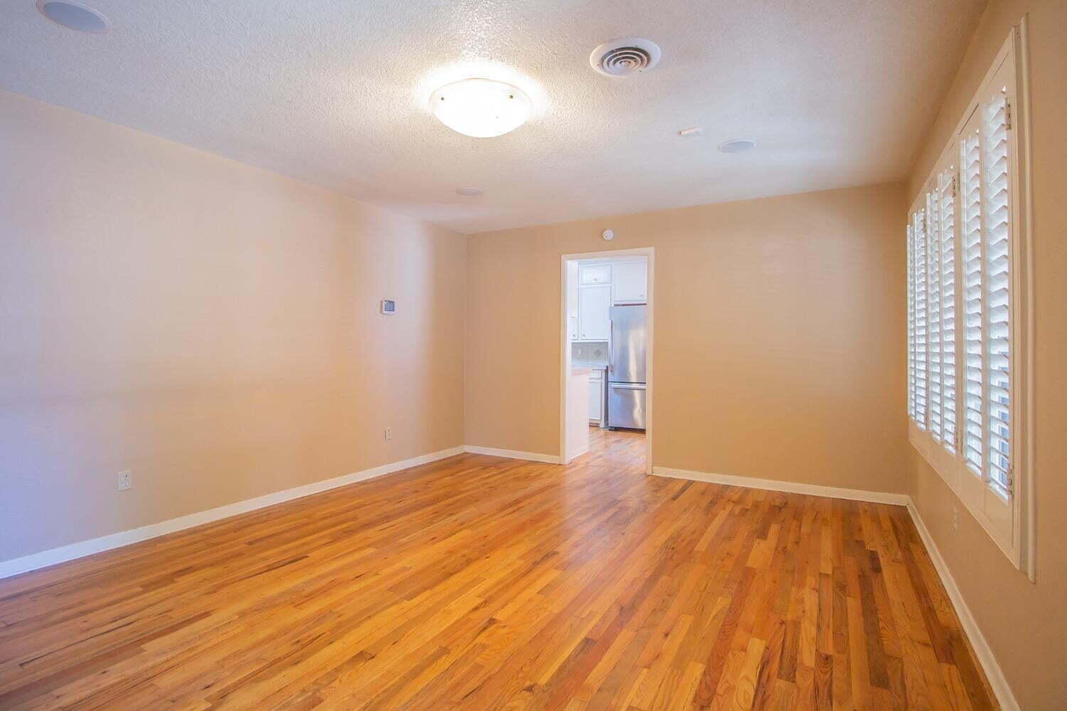 3813 35th Street Lubbock, TX 79413 - Photo 4 of 18 wooden floor in an empty room with a window
