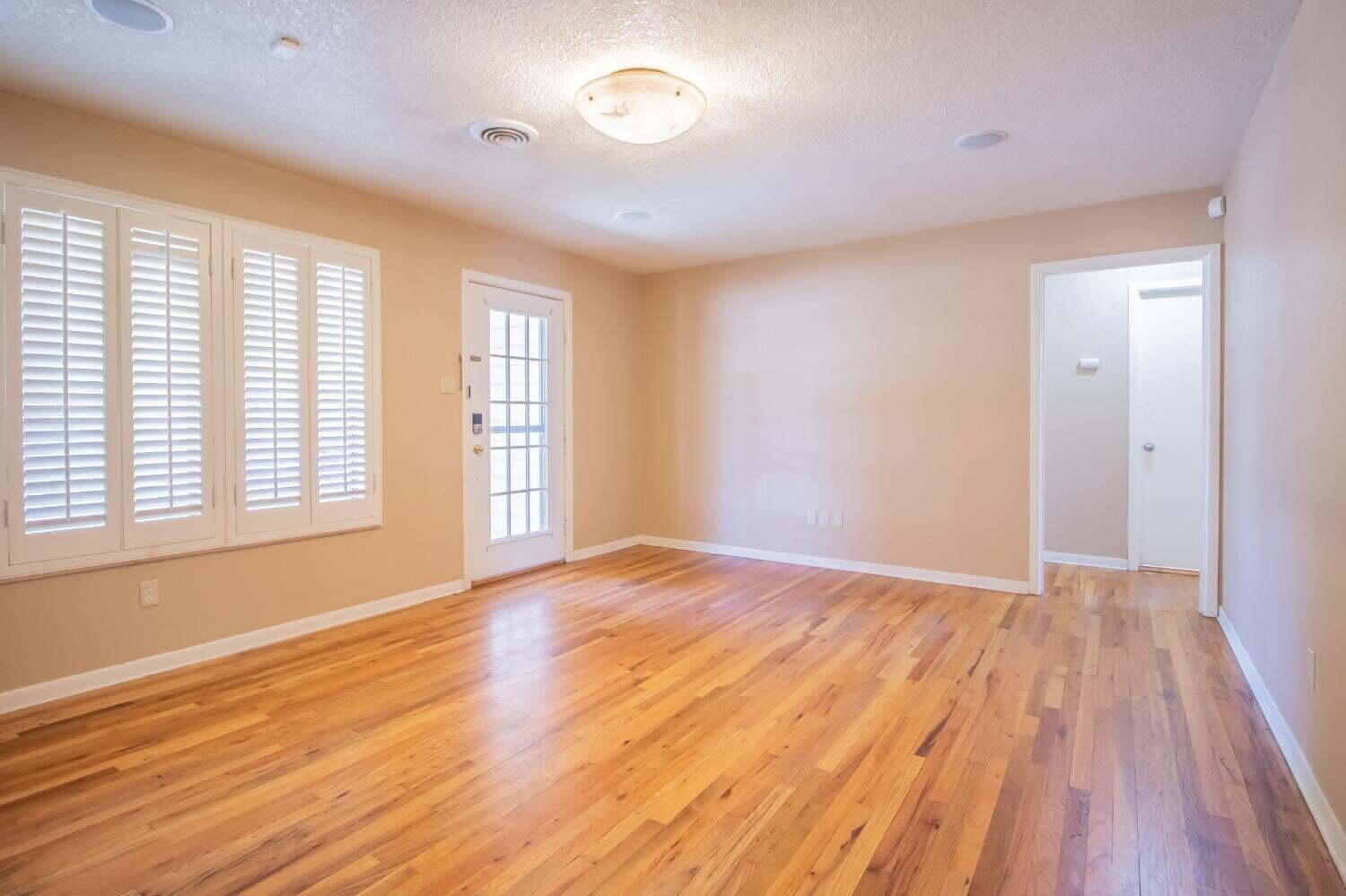 3813 35th Street Lubbock, TX 79413 - Photo 5 of 18 a view of an empty room with wooden floor and a window