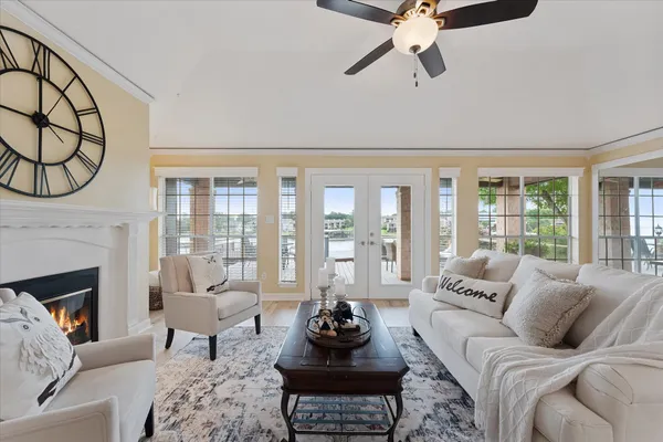 a living room with furniture a fireplace and a floor to ceiling window