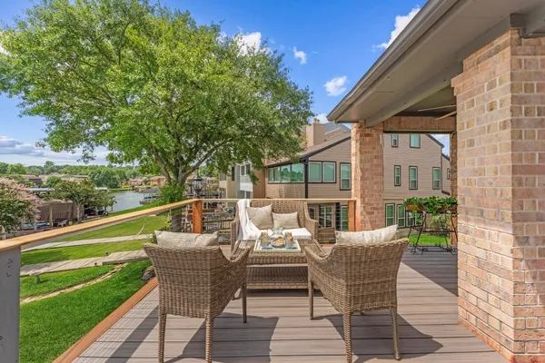 a balcony with wooden floor table and chairs
