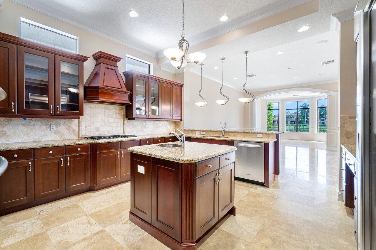 9636 Bridgebrook Drive Boca Raton, FL 33496 - Photo 11 of 50 a kitchen with a stove kitchen island and stainless steel appliances