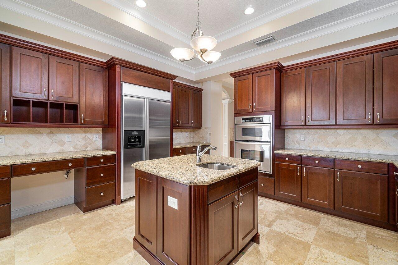 9636 Bridgebrook Drive Boca Raton, FL 33496 - Photo 13 of 50 a kitchen with kitchen island granite countertop stainless steel appliances a sink stove and refrigerator