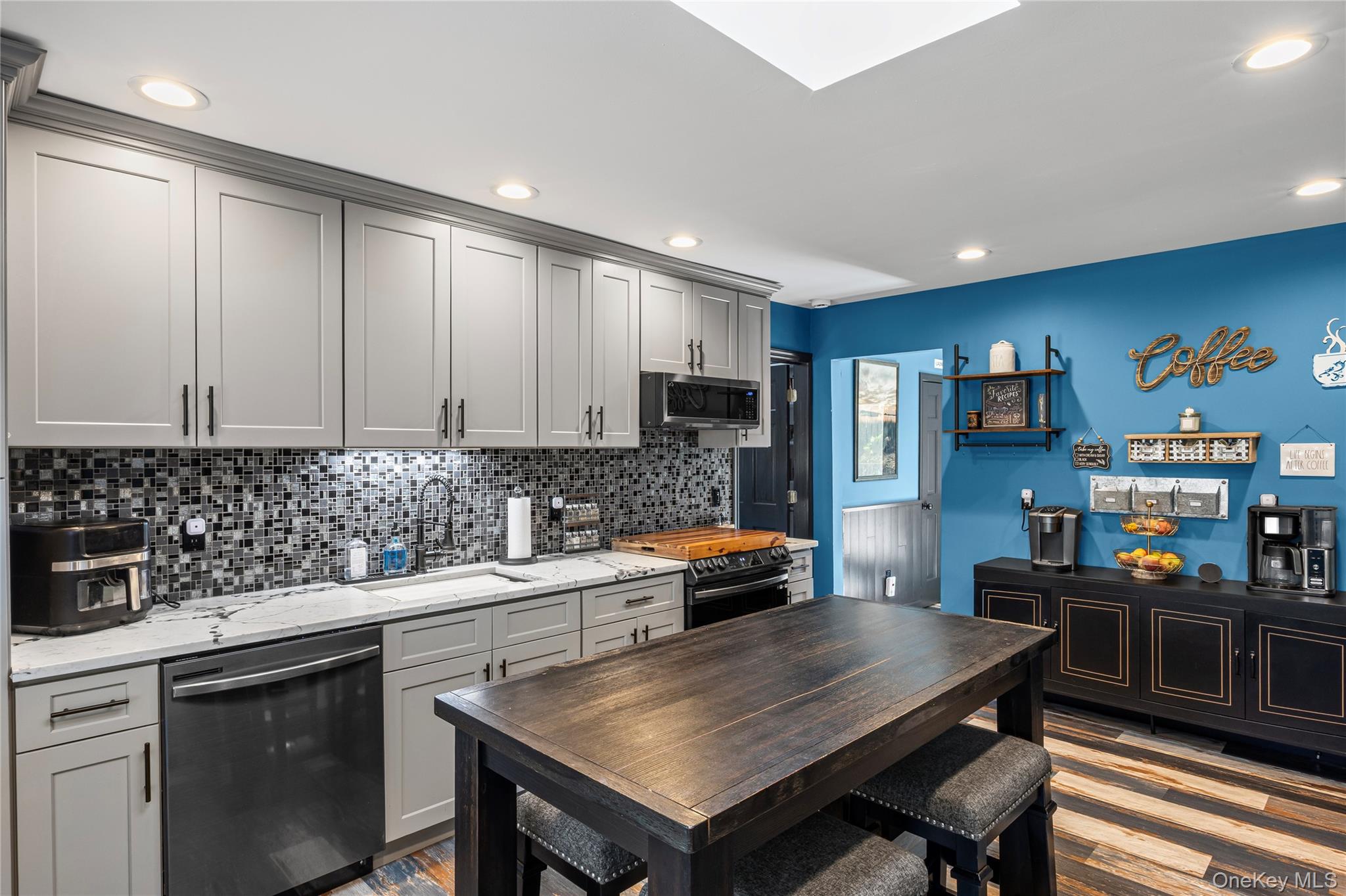 4 Model Court Rocky Point, NY 11778 - Photo 12 of 36 a kitchen with stainless steel appliances a stove a sink a microwave a dining table and chairs