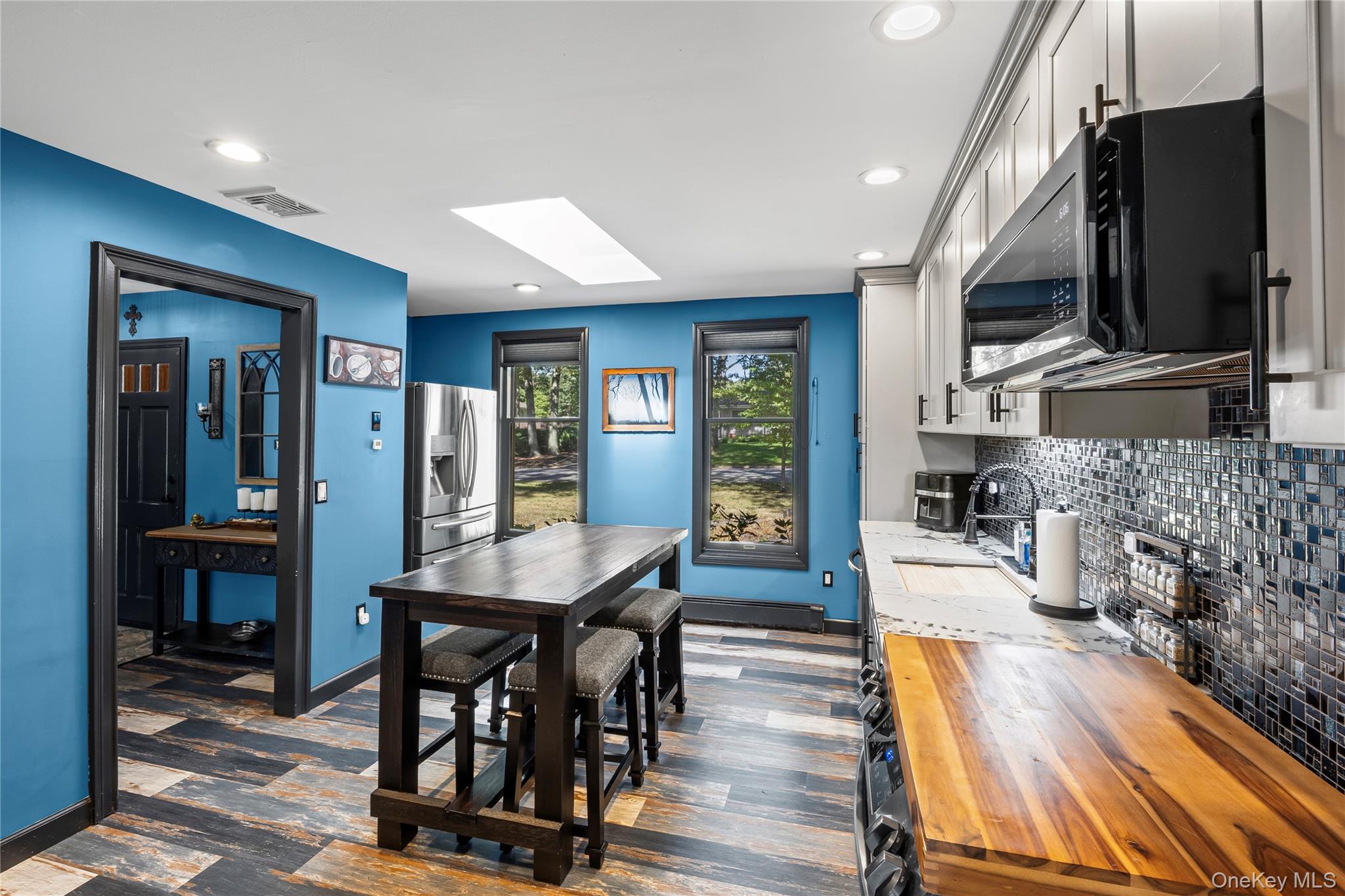4 Model Court Rocky Point, NY 11778 - Photo 14 of 36 a living room with furniture dining table a flat screen tv and a refrigerator