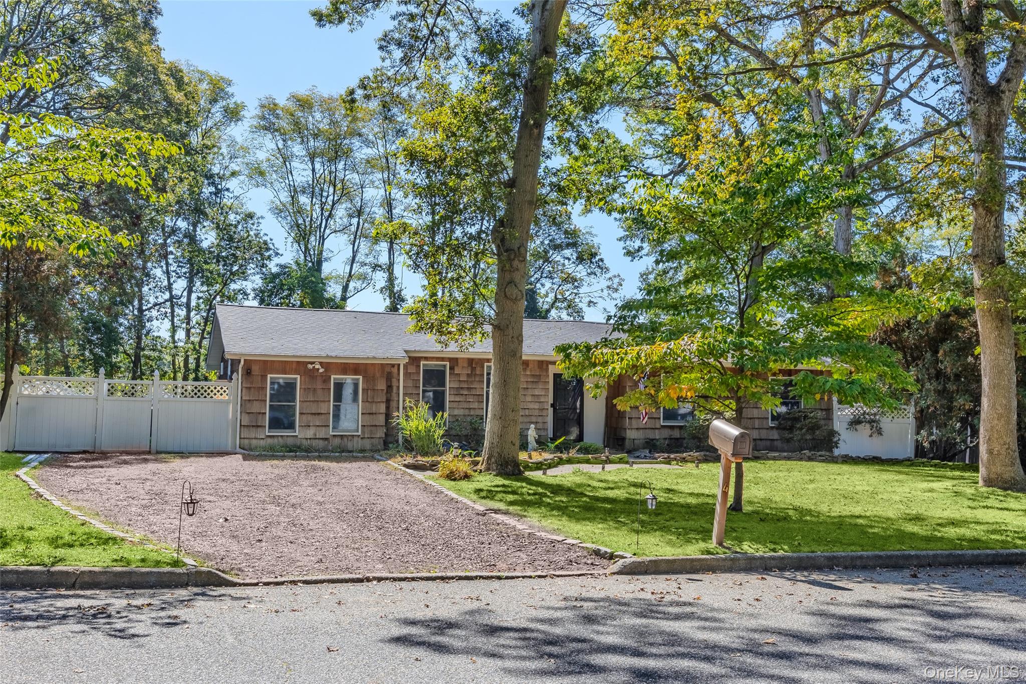 4 Model Court Rocky Point, NY 11778 - Photo 2 of 36 a front view of a house with a yard and tree s