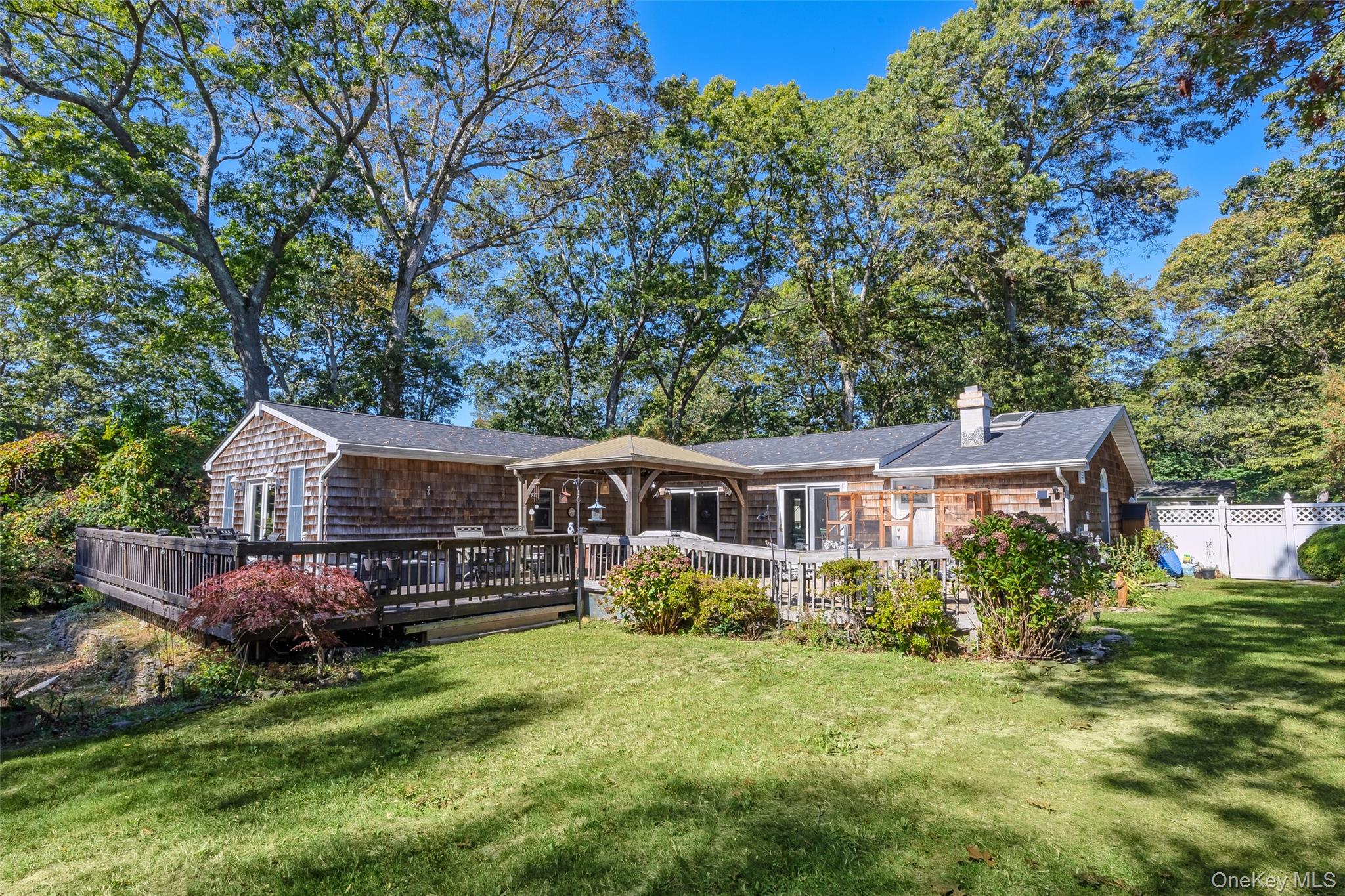 4 Model Court Rocky Point, NY 11778 - Photo 4 of 36 a front view of a house with a garden and deck