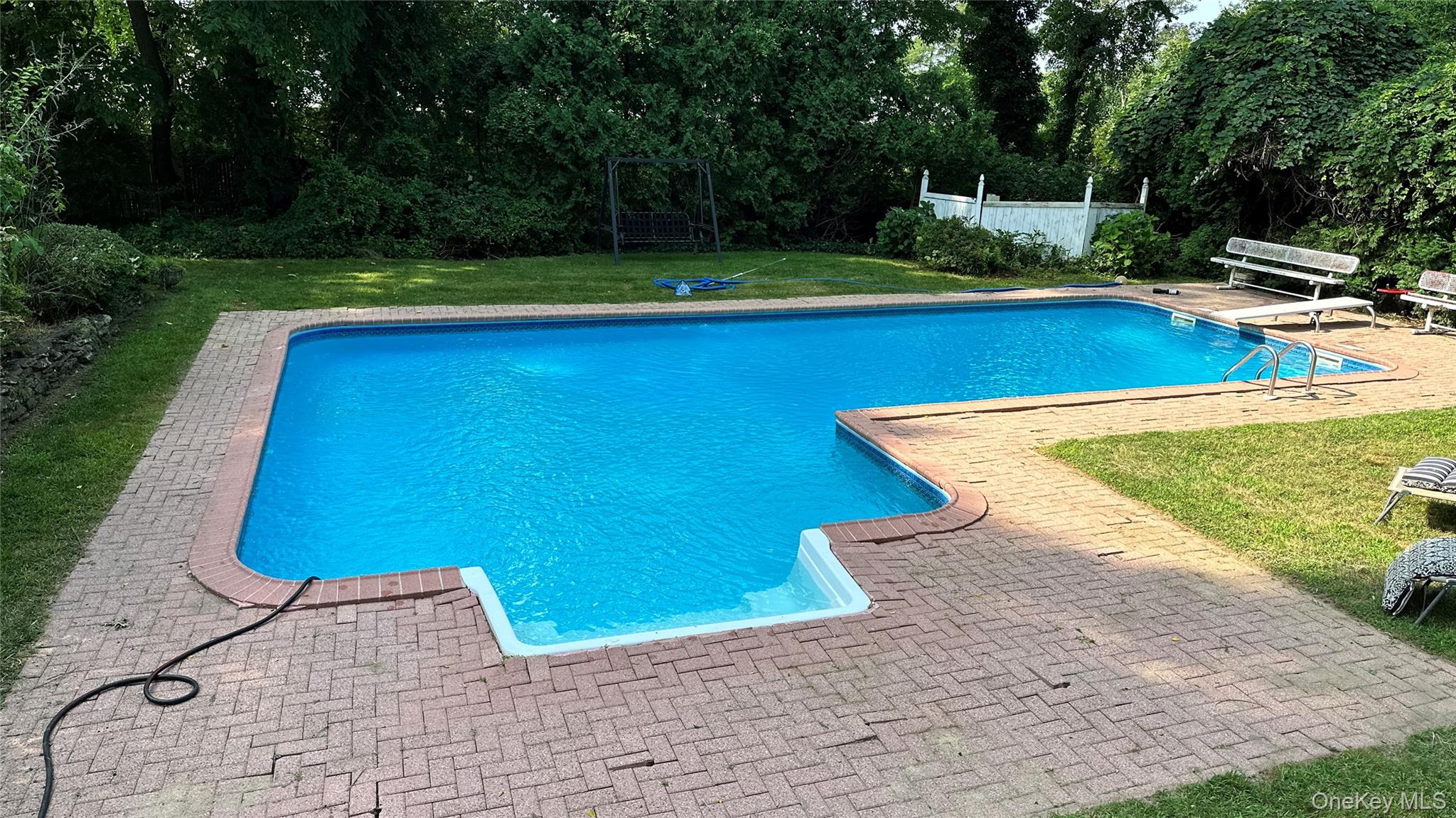 4 Model Court Rocky Point, NY 11778 - Photo 6 of 36 a view of a swimming pool with lawn chairs plants and large trees