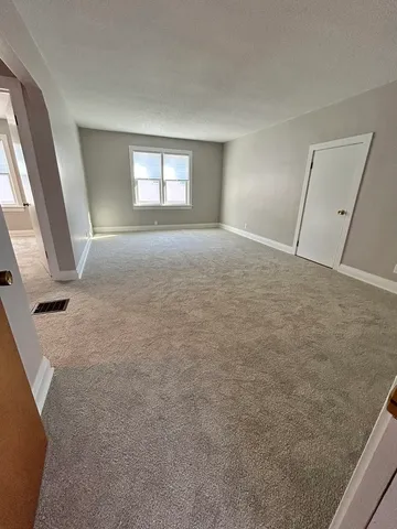 an empty room with a ceiling fan and window