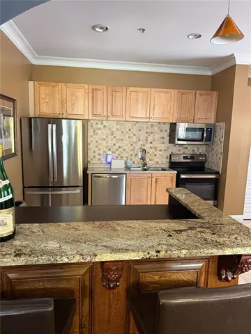 a kitchen with stainless steel appliances granite countertop a sink and a stove