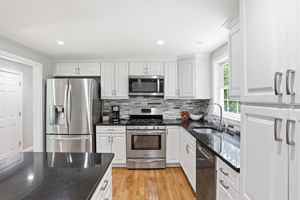 33 Simon Willard Road Acton, MA 01720 - Photo 11 of 42 a kitchen with granite countertop a refrigerator stove and sink
