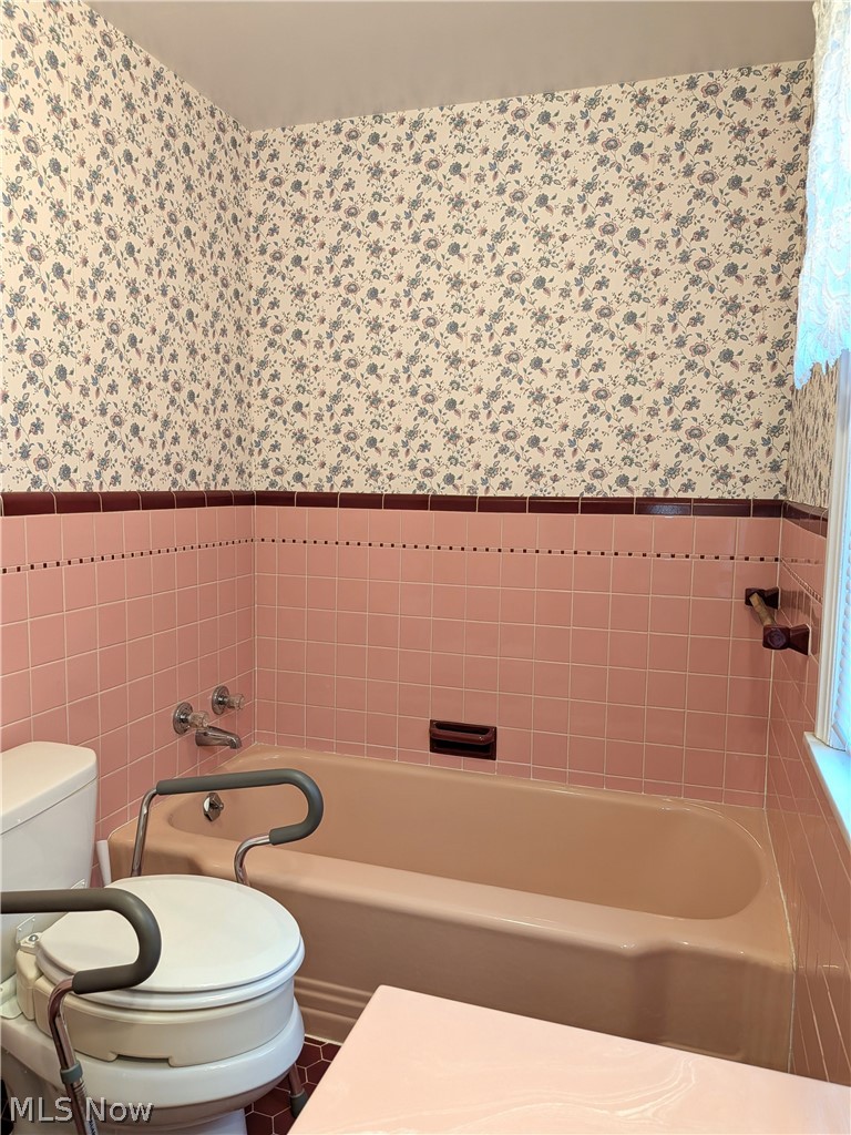 2316 Glendon Road Cleveland, OH 44118 - Photo 17 of 22 Full bathroom with wallpapered walls, washtub / shower combination, wainscoting, and tile walls