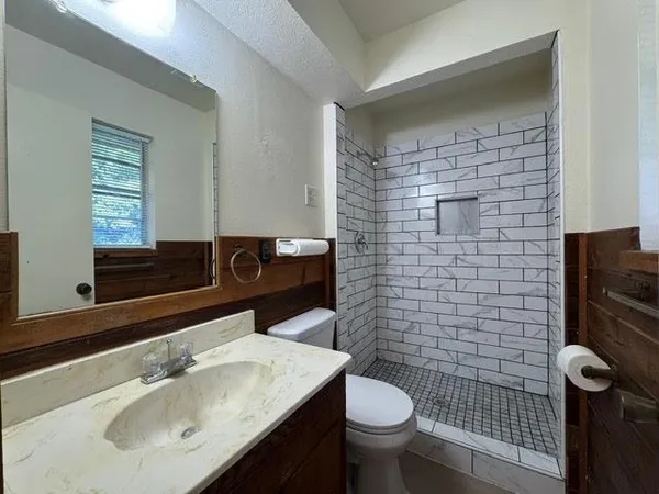 a bathroom with a sink toilet and mirror