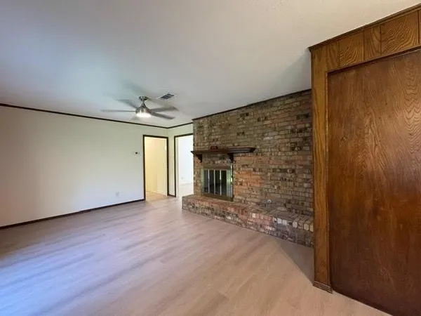 a view of a livingroom with wooden floor and a ceiling fan