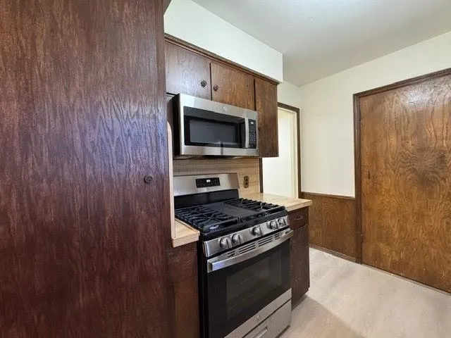 a kitchen with granite countertop a stove and a microwave