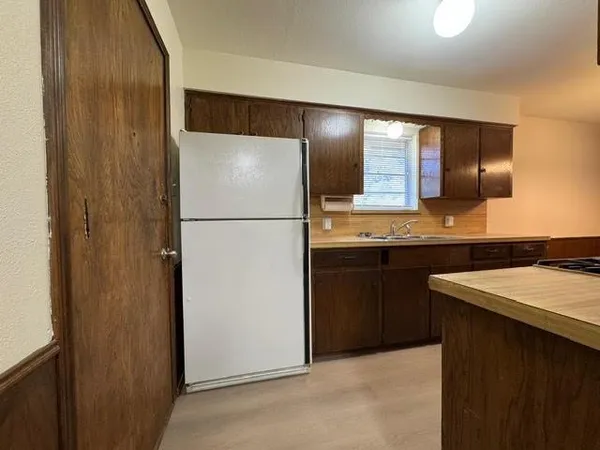 a kitchen with stainless steel appliances granite countertop a refrigerator a sink and a refrigerator