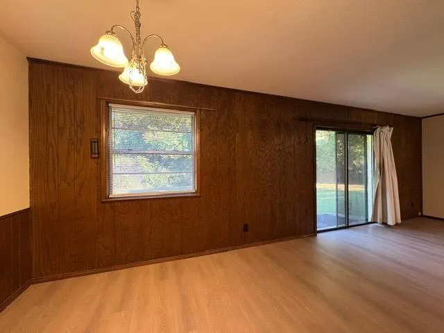 a view of a livingroom with a chandelier fan and wooden floor