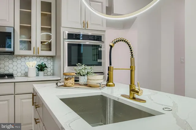 a large white bathroom with a bathtub a sink and a large mirror