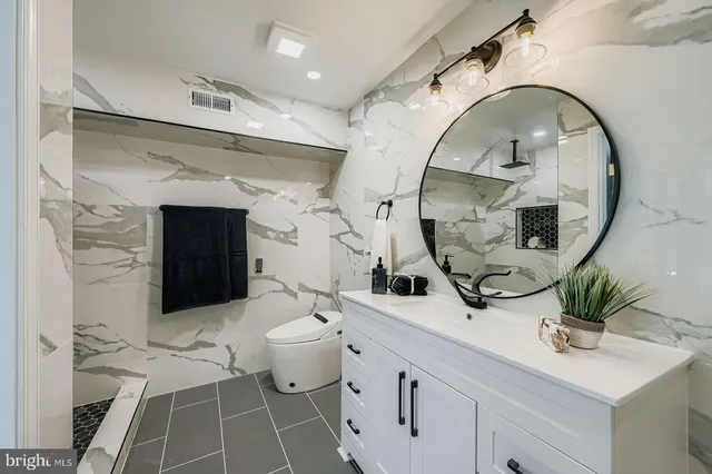 a bathroom with a sink a toilet and a mirror