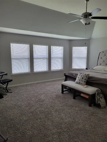 a spacious bedroom with a bed and a chandelier