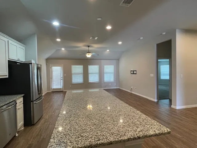 a view of a kitchen with refrigerator and wooden floor