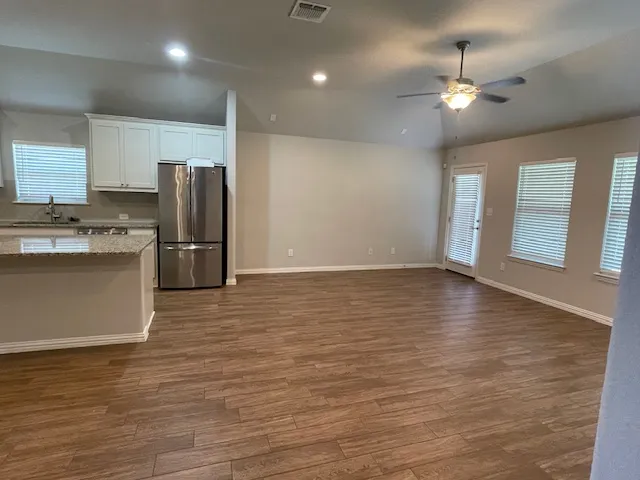 a view of a kitchen with a sink and refrigerator