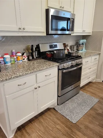 a kitchen with white cabinets stainless steel appliances and sink