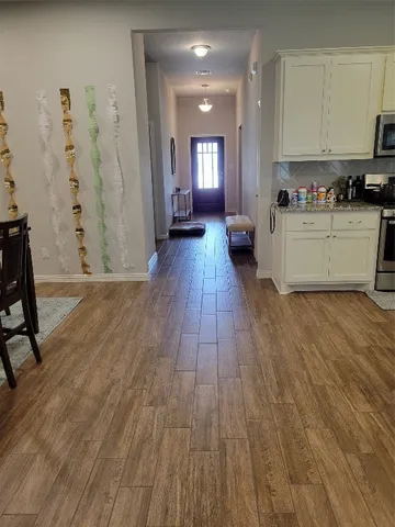 a view of a kitchen with cabinets and wooden floor