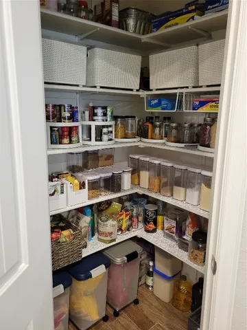 a kitchen with white cabinets and a wooden floor