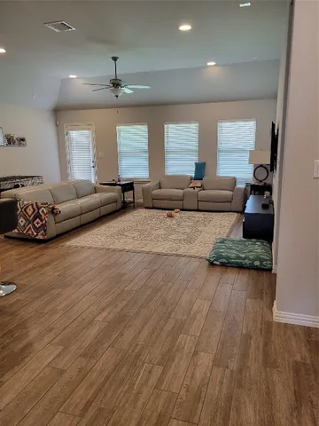 a living room with furniture and a wooden floor
