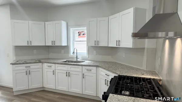 a kitchen with white cabinets and a stove