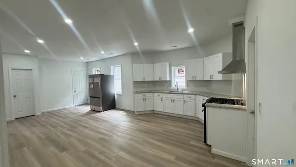 a kitchen with stainless steel appliances granite countertop a stove a sink and a refrigerator