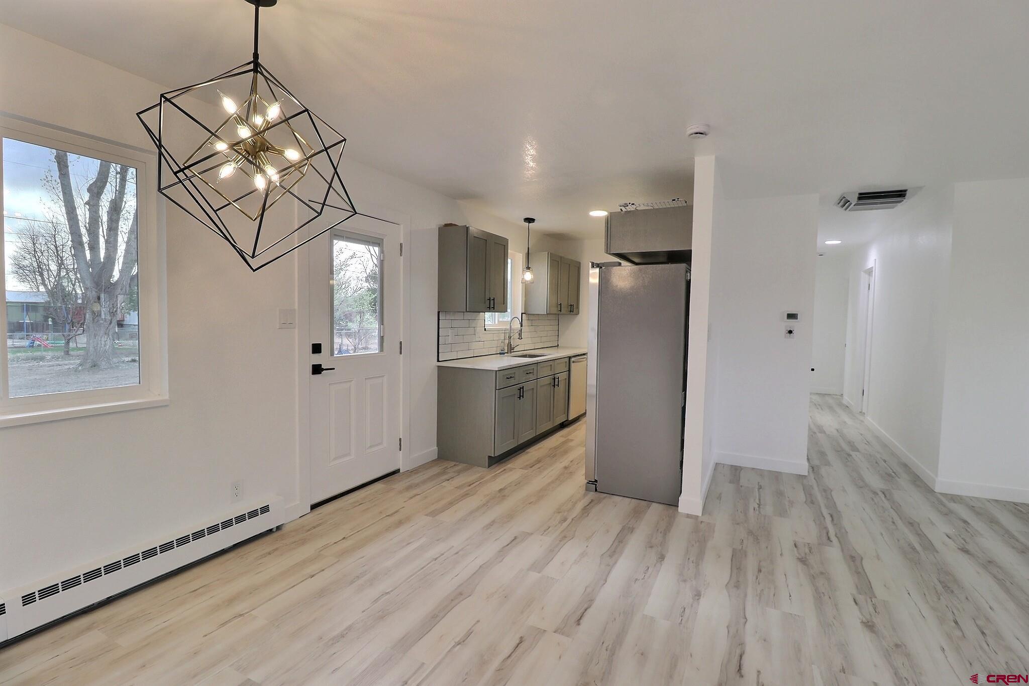 525 Sloan Street Delta, CO 81416 - Photo 4 of 26 a kitchen with stainless steel appliances granite countertop a refrigerator a sink dishwasher a stove and white countertops with wooden floor