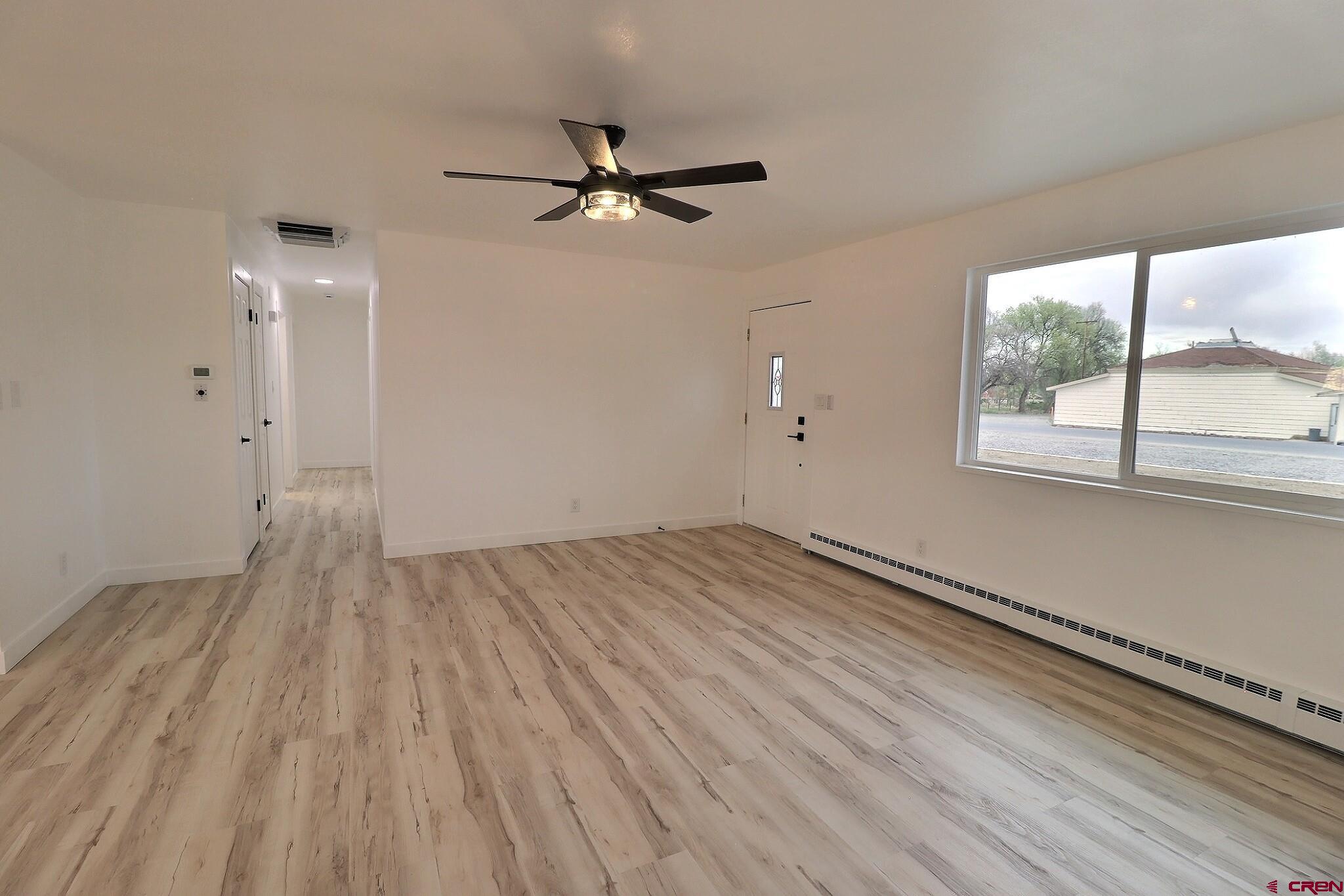 525 Sloan Street Delta, CO 81416 - Photo 8 of 26 an empty room with wooden floor fan and windows