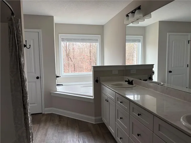 a bathroom with a granite countertop sink and a window