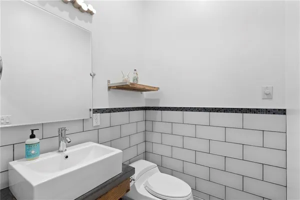 a bathroom with a sink toilet and a mirror