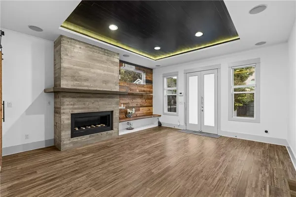 a view of an empty room with wooden floor fireplace and a window