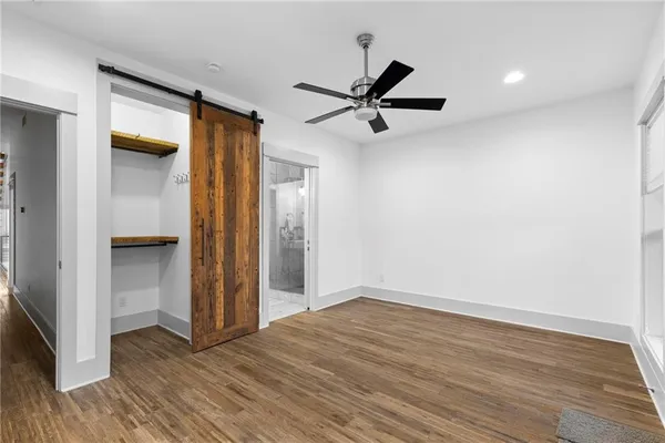 a view of empty room with wooden floor and window