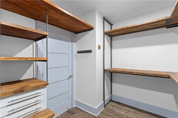 a view of a hallway with wooden floor and a window