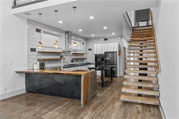 a kitchen with stainless steel appliances kitchen island granite countertop a refrigerator and a stove top oven