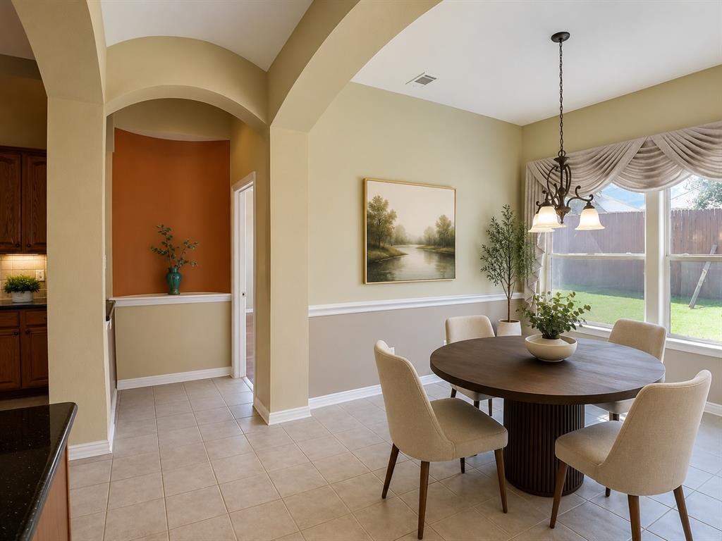 5708 Rickshaw Lane Plano, TX 75094 - Photo 14 of 28 Dining area featuring tile flooring, a window with backyard views, and a decorative chandelier