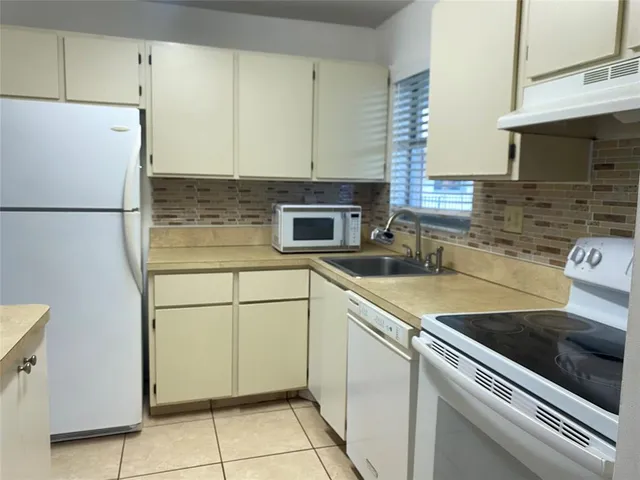 a kitchen with a refrigerator and a sink