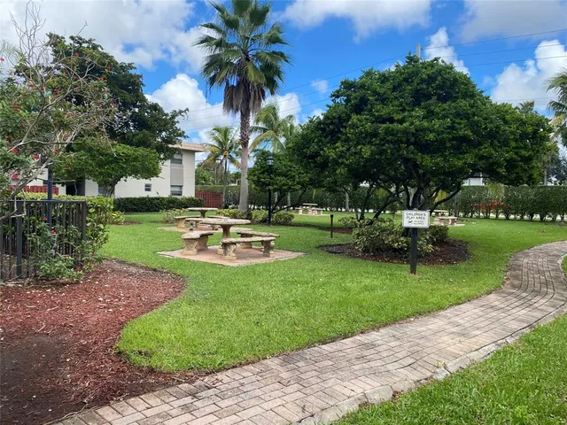 a front view of a house with garden and trees