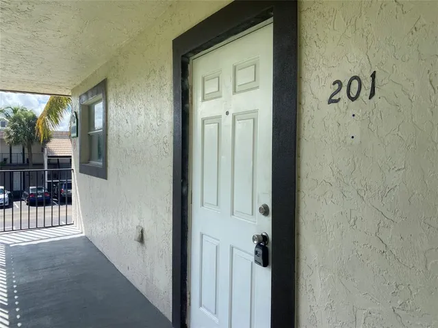 a view of a hallway with a door and wooden floor