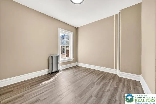 a view of an empty room with wooden floor