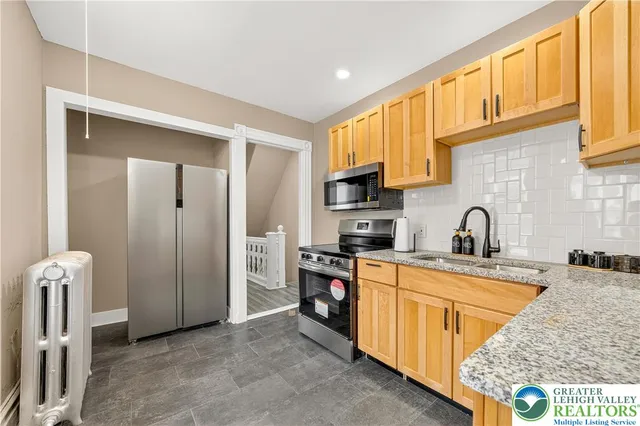 a kitchen with stainless steel appliances granite countertop a stove a sink and a microwave