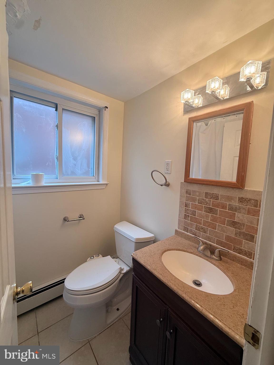 216 Boro Road, Unit A Secane, PA 19018 - Photo 18 of 26 a bathroom with a granite countertop toilet sink and mirror