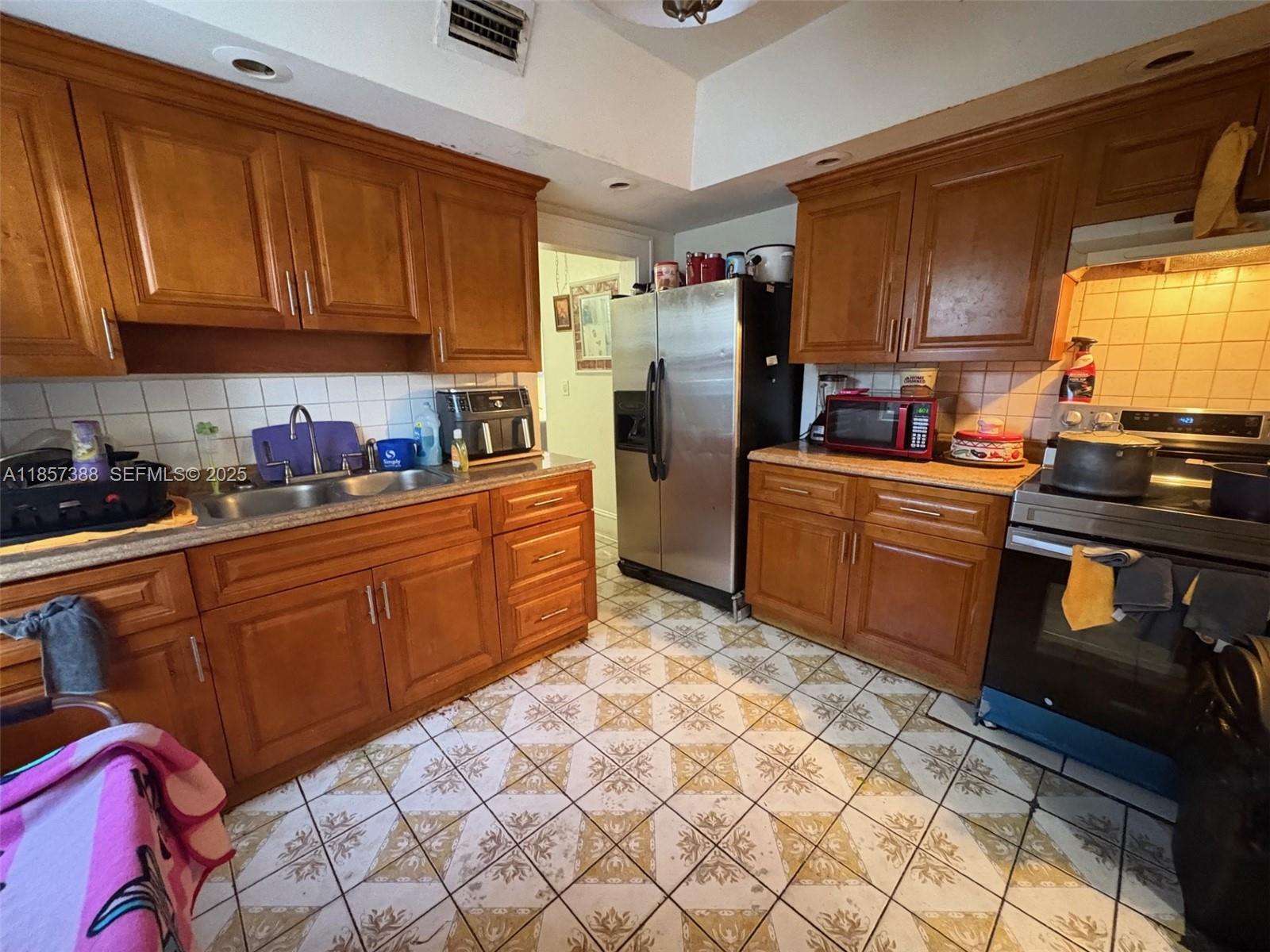 2619 Southwest 5th Street Miami, FL 33135 - Photo 13 of 17 a kitchen with stainless steel appliances granite countertop a refrigerator sink and cabinets