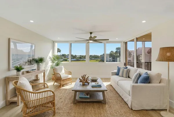 a living room with patio furniture and a potted plant