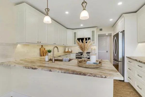 a spacious bedroom with a large bed and a chandelier