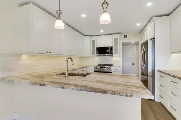 a bathroom with a granite countertop sink toilet mirror and shower